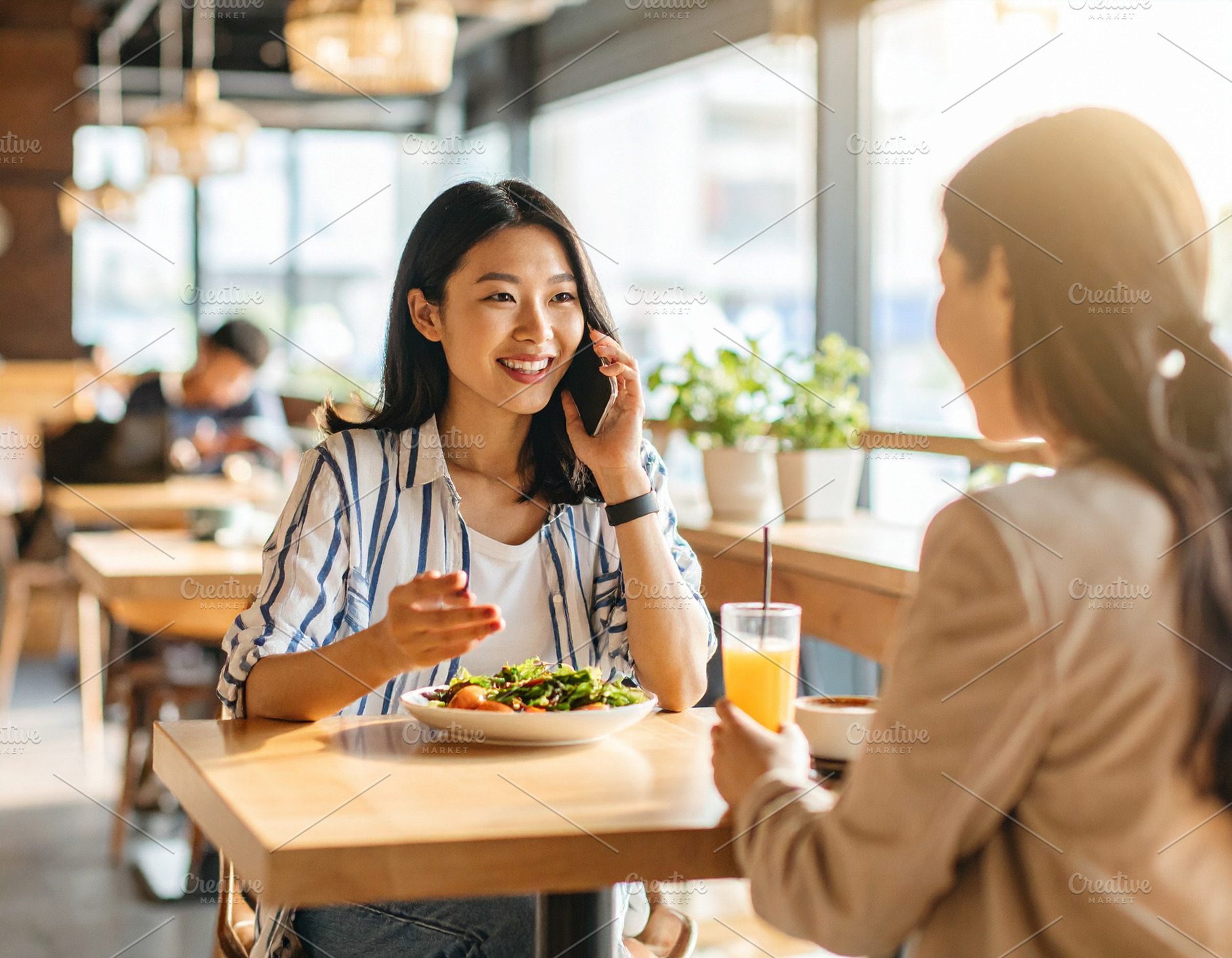 Women enjoying lunch and conversation in cafe, a Person Photo by DanFLCreativo