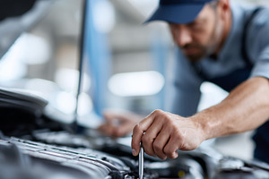 Focused car mechanic works under the, a Transportation Photo by MistyDay