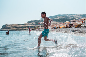 Boy running into water during summer, a Sports & Recreation Photo by HalfPoint