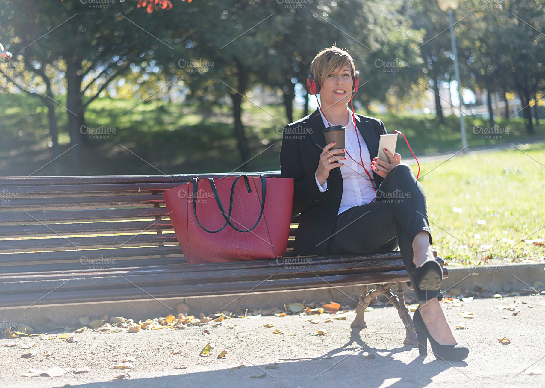 Businesswoman relaxing with coffee and smartphone, a Photo by RF Images
