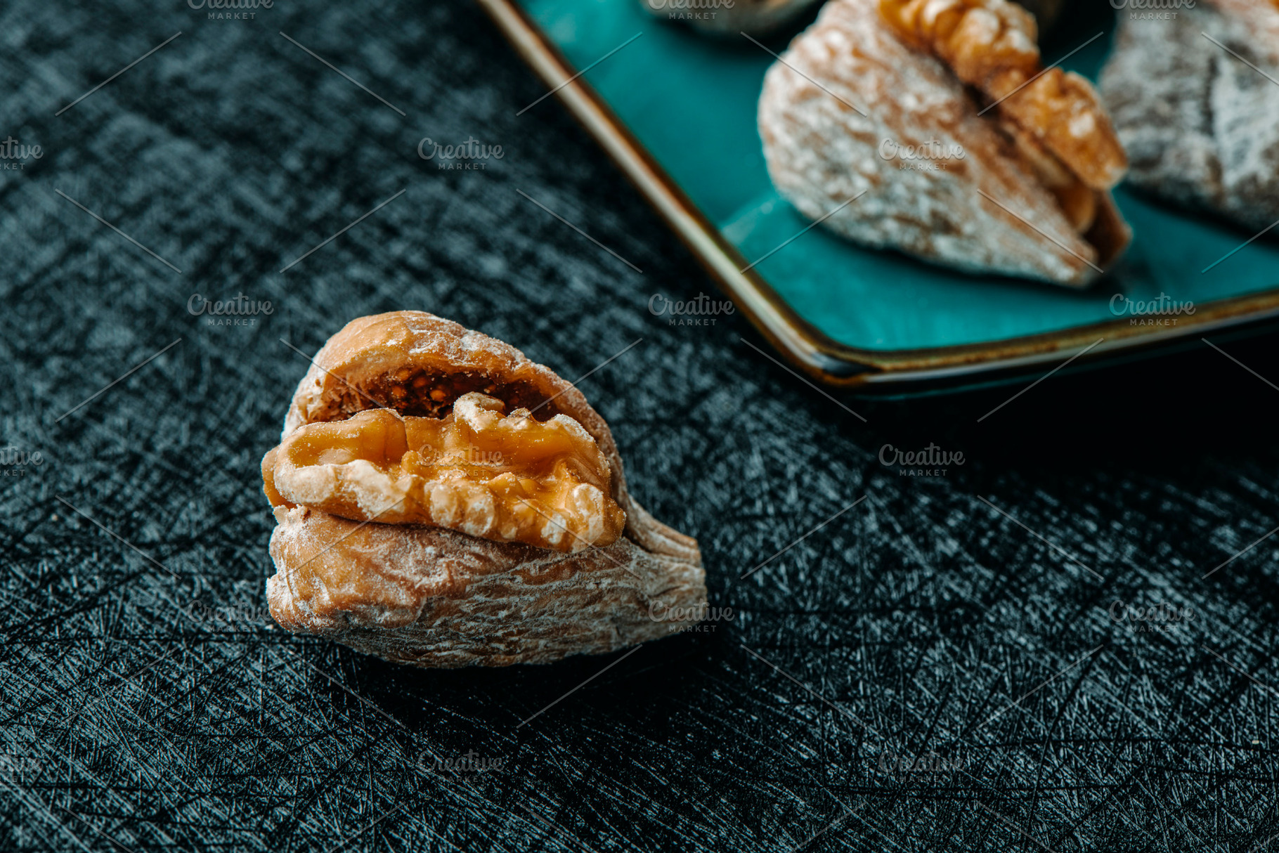 a dried fig filled with half walnut on a table, a Photo by Nito