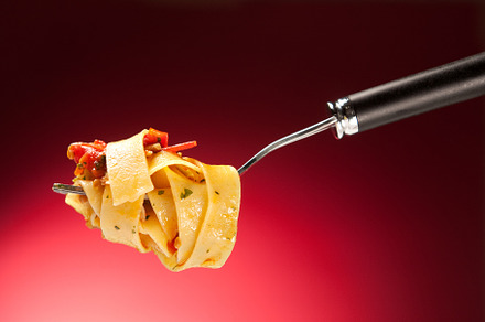 Tagliatelle with clams on a red background