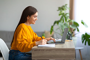 Positive young woman writing in notebook during online lecture on laptop, commu, a Photo by Prostock-Studio (Thumbnail 2 of 3)