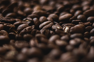 Roasted coffee beans scattered, forming a textured background. A, a Photo by Studio ANNA