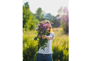 Young woman holds wild flowers, a Beauty & Fashion Photo by Fascinadora
