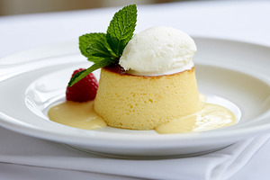 Creamy baked custard dessert with a scoop of vanilla ice cream, fresh mint leav, a Photo by Studio ANNA