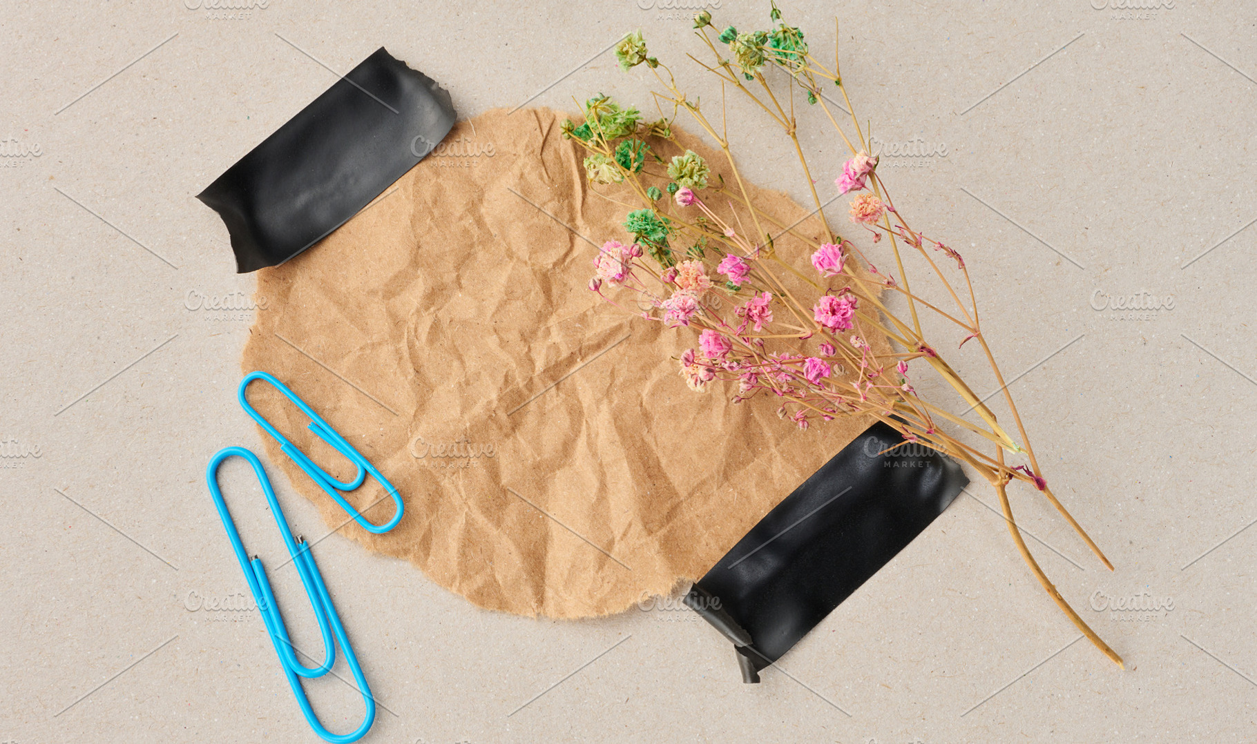 Crumpled brown paper secured with black tape, sprigs of pink and, a Background Photo by ndanko