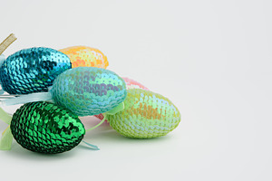 Decorative Easter eggs with sequins on a white background, a Holiday Photo by ndanko