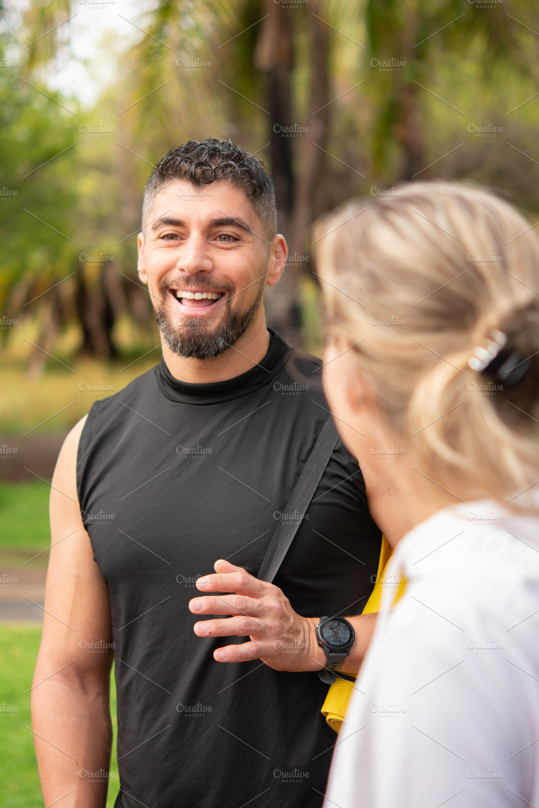 Smiling man talking to woman during outdoor workout session in park, a Sports & Recreation Photo by etorres69