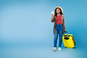 Black female using cellphone, booking hotel or vacation on web, using online tr, a Photo by Prostock-Studio