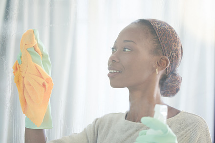 Cleaning, window and black woman with spray and cloth for dust, bacteria and housekeeping service. Disinfection, hygiene and cleaner with girl and glass surface at home for washing, germs or sanitize, a Photo by Peopleimages.com