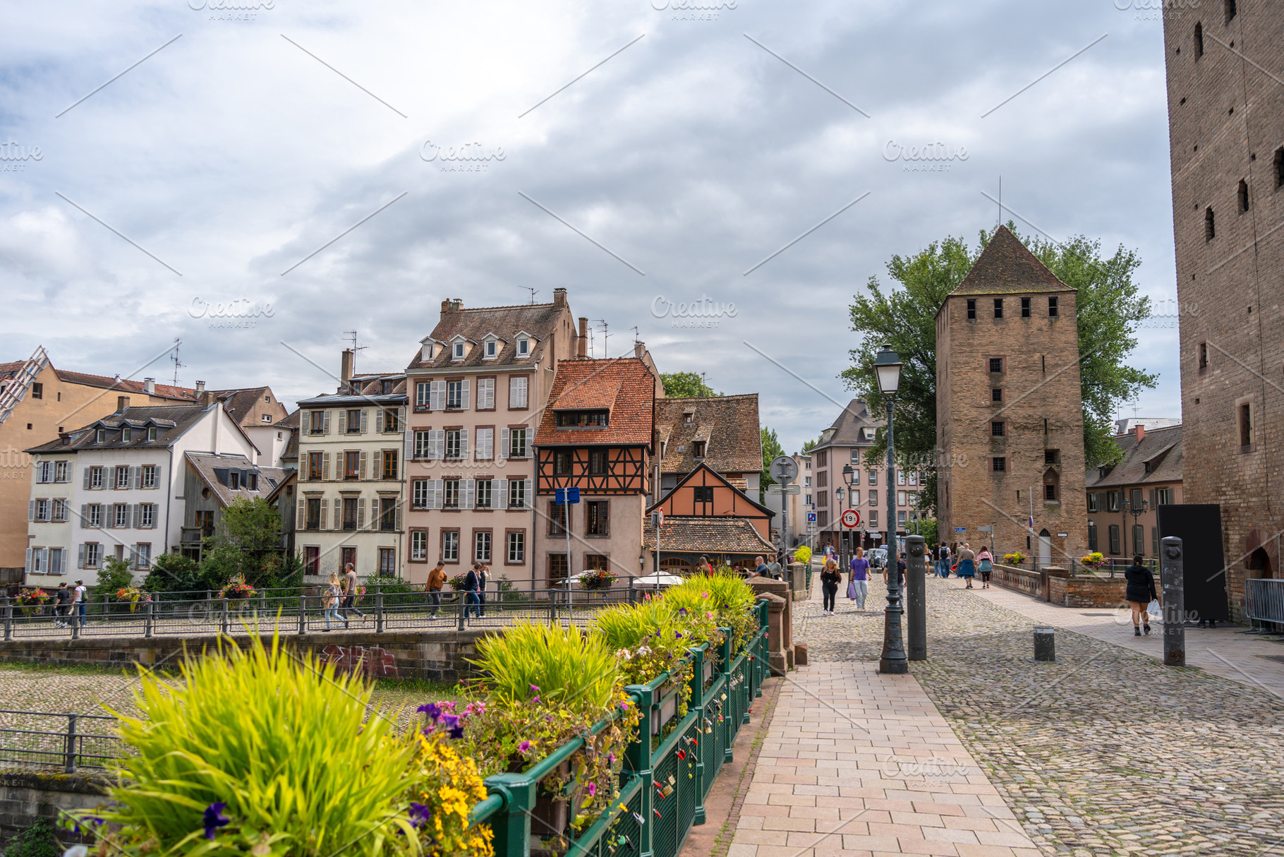 Cobblestone bridge and medieval tower in Strasbourg, France, an Architecture Photo by GoodGoods