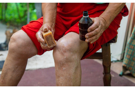 Grandmother treats her knees with, a Health & Medical Photo by yanadjana