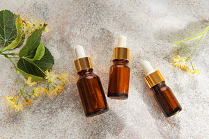 Linden blossom herbal oil serum cosmetic bottles on concrete, a Health & Medical Photo by Olena Rudo