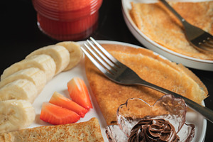 A plate of crepes filled with chocolate spread and topped with banana slices an, a Food & Drink Photo by Budarinphoto