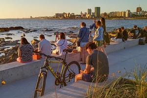 People enjoying golden hour by the waterfront promenade, a Person Photo by DanFLCreativo