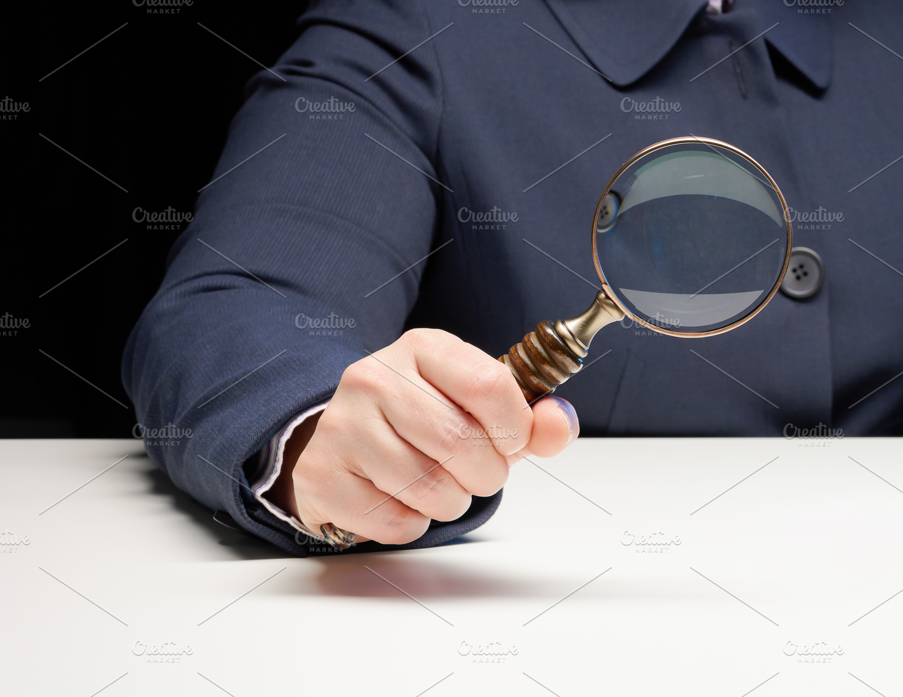 A woman's hand in a blue jacket holds an antique magnifying glas, a Person Photo by ndanko