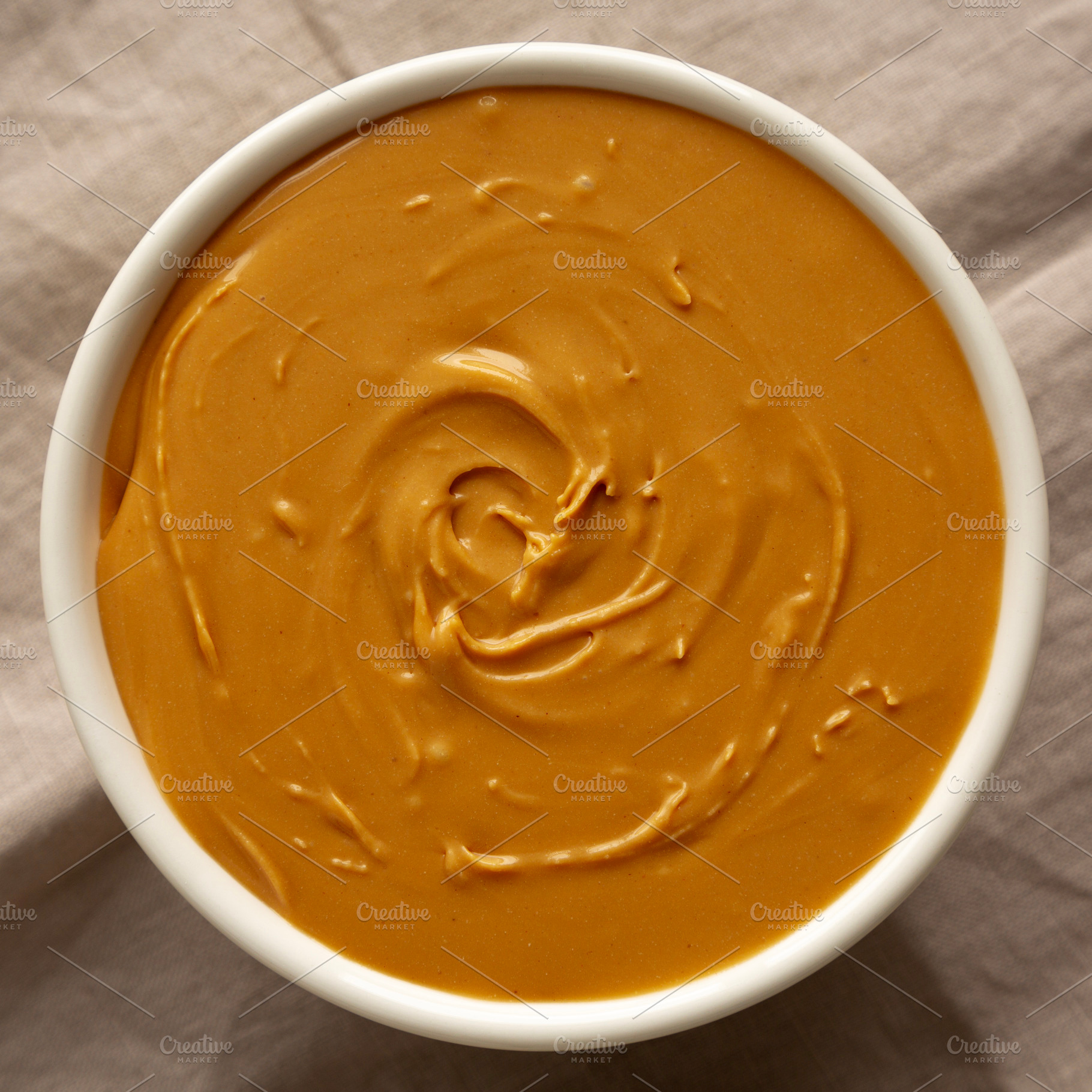 Organic Peanut Butter in a Bowl, top view. Flat lay, overhead., a Food & Drink Photo by LiudmylaChuhunova