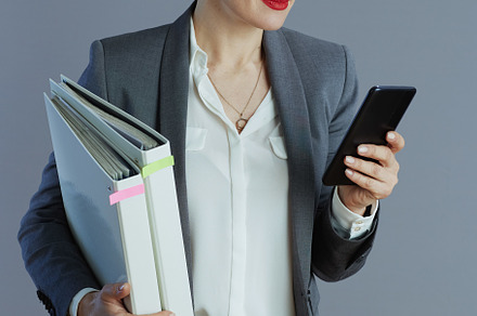 modern 40 years old woman worker against gray background, a Business Photo by Alliance Images