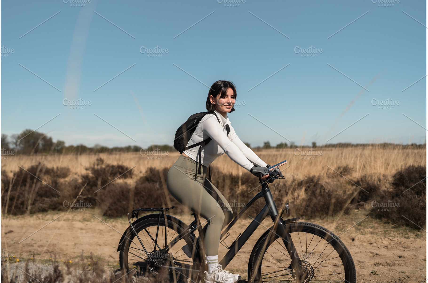 Female cyclist rides a sandy coastal, a Nature Photo by AD Stock Images