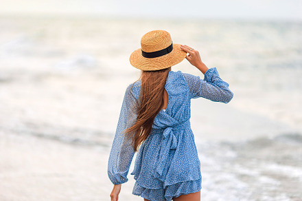 Adorable young girl with beautiful long hair enjoy tropical beach vacation. The