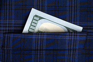 Close-up of a US hundred dollar bill partially visible in a blue plaid pocket,, a Business Photo by Ales Munt