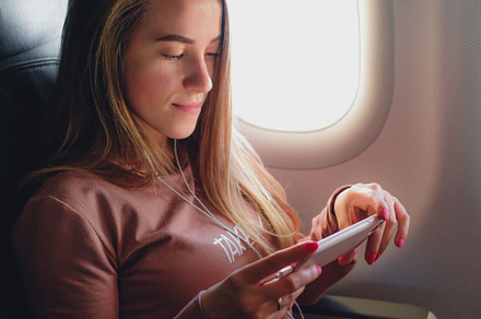 Girl is reading from smartphone in airplane stock photo containing airplane