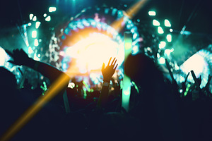 Rock concert with silhouettes people in happy gesture and raisin
