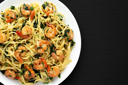 Homemade One-Pot Lemon Garlic Shrimp Pasta on a Plate on a black, a Food & Drink Photo by LiudmylaChuhunova