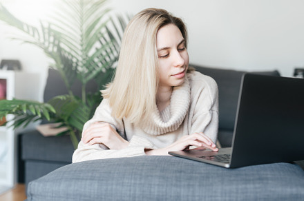 Young woman working on laptop in  home, a Person Photo by Olena Rudo