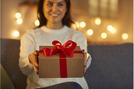 Happy woman smiling and holding out, a Holiday Photo by StudioRomantic
