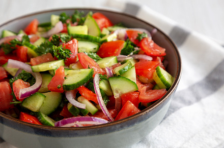 Homemade Mediterranean Cucumber Tomato Salad in a Bowl, side vie, a Food & Drink Photo by LiudmylaChuhunova