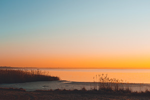 Colorful sunset on the lake containing sunset, sky, and sun