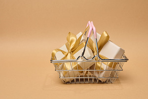 A stack of boxes tied with a golden ribbon on a beige background, a Holiday Photo by ndanko