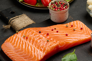 Whole piece of fresh salmon on a black cutting board, next to a, a Food & Drink Photo by ndanko