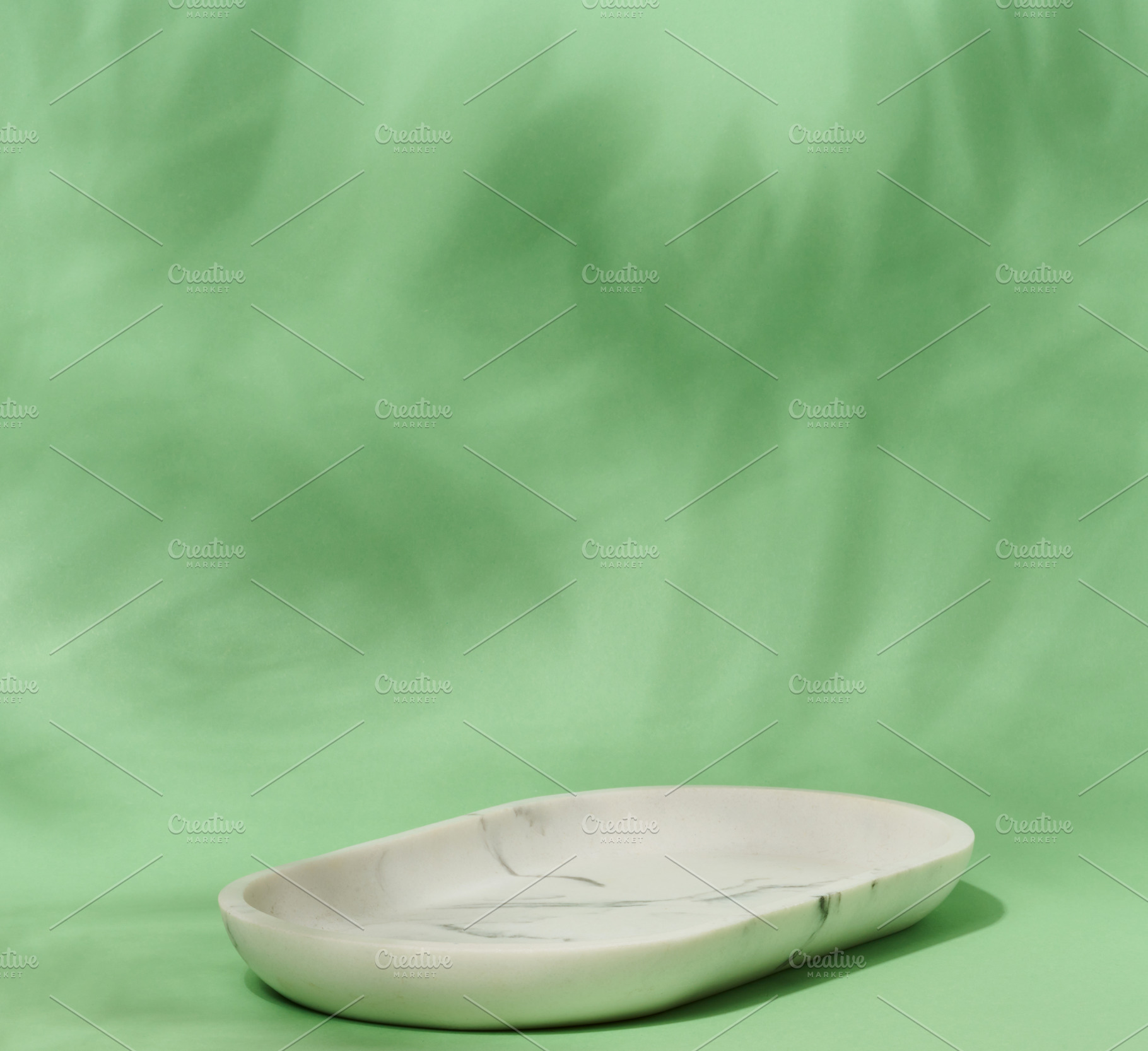 An empty, oval shaped soap dish made of white marble with gray v, a Photo by ndanko