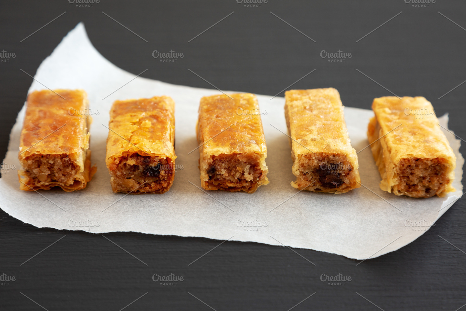 Homemade Baklavas with Honey, Chocolate and Almond on a black ba, a Food & Drink Photo by LiudmylaChuhunova
