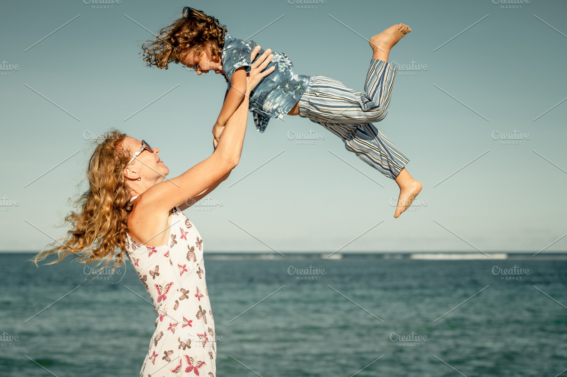 Mother and  son playing on the beach stock photo containing family and, a Person Photo by altanaka