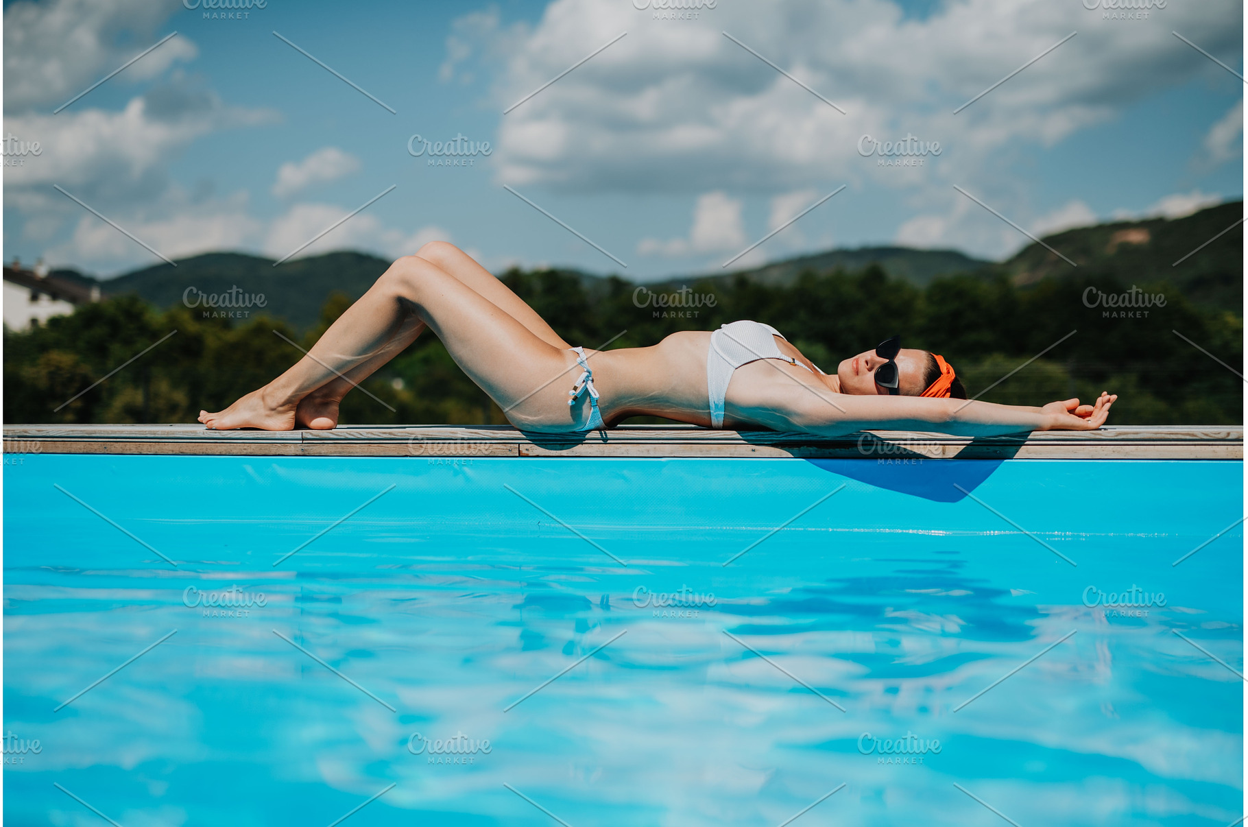 Young woman lying by the on edge of, a Person Photo by HalfPoint