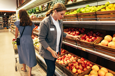 Female grocery store worker stands