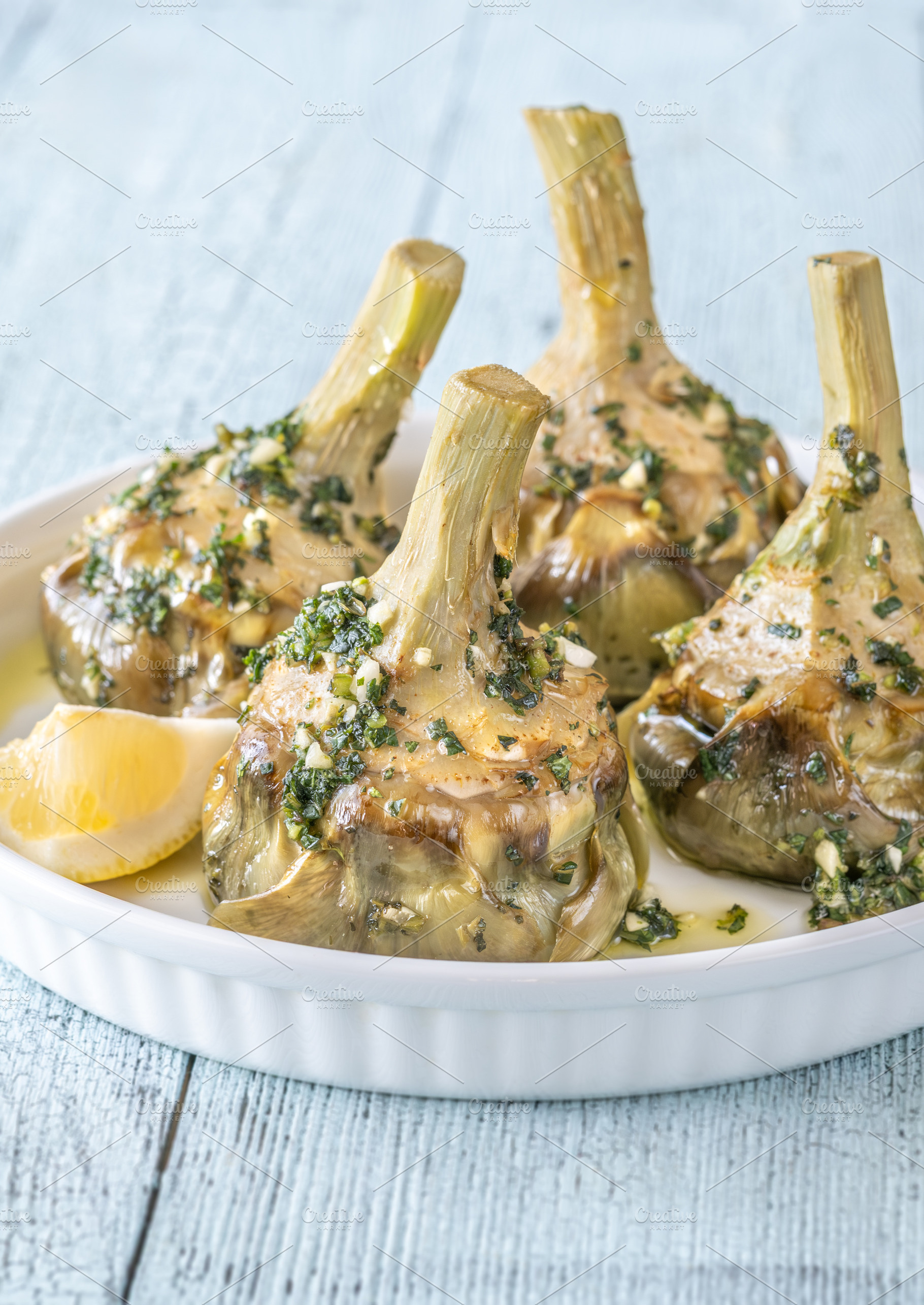 Four Roman-style artichokes served o, a Food & Drink Photo by Alexander Prokopenko