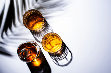 Whiskey in glasses and bottle, white background with hard light,, a Food & Drink Photo by 5PH