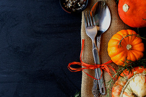 Seasonal wooden table setting with small pumpkins containing table