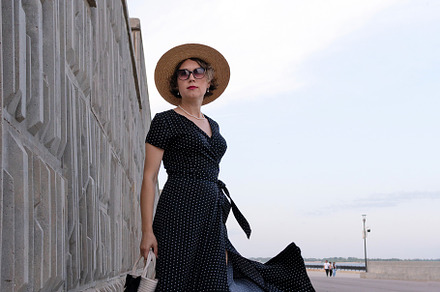 Confident woman in black dress stand