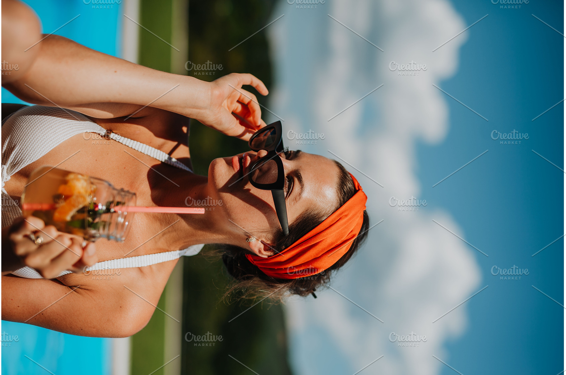 Young woman sitting by swimming pool, a Person Photo by HalfPoint
