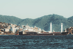 Rotor sail cargo ship near coast, a Transportation Photo by SkyNext