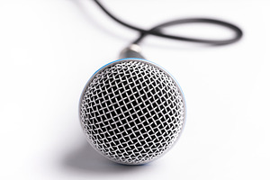 Close-up of a microphone with black cable on a clean white backg, a Business Photo by Ales Munt