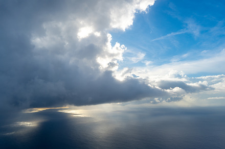 Dramatic sky with sunbeams and clouds seen from an airplane