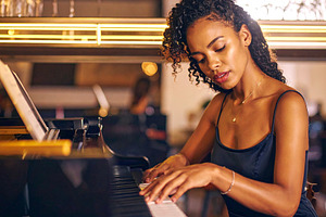 Adult pianist performing at the piano in a small bar, a Person Photo by DanFLCreativo