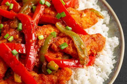 Homemade Simple Chili Chicken with White Rice on a Plate on a bl, a Food & Drink Photo by LiudmylaChuhunova